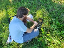 Scientist with microscope in orchard